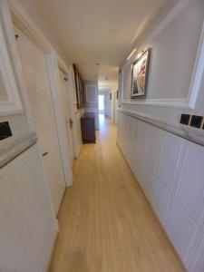 塞拉莱الشقة البحرية الدهاريز的走廊设有白色墙壁和木地板
