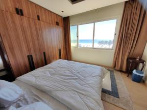 塞拉莱الشقة البحرية الدهاريز的一间卧室设有一张大床和大窗户