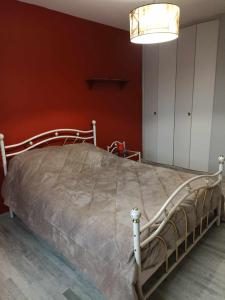 Saint-LoupMaison de village的红色墙壁的房间里一张床位