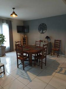 Saint-LoupMaison de village的一间带木桌和椅子的用餐室