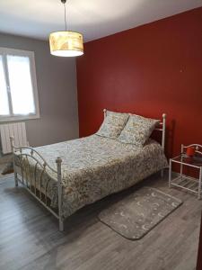Saint-LoupMaison de village的一间卧室设有一张床和红色的墙壁