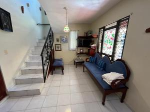 圣地亚哥洛斯卡巴萨纳萨尔瓦多亚尔丁赛克勒托旅舍的客厅设有蓝色的沙发和楼梯。