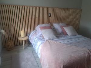 比奇le refuge du bonheur的一间卧室设有一张床和木墙
