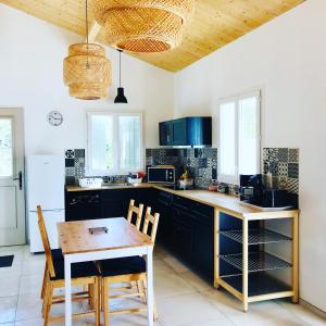 勒沙托多莱龙Boinot Lodge的厨房配有黑色橱柜和木桌及椅子