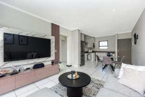 SandtonExclusive apartment in Fourways的客厅配有大屏幕平面电视