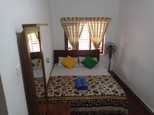 希克杜沃The Villa Hush的一间卧室配有一张带色彩缤纷枕头的床和窗户。