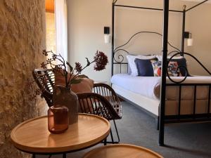 卡尔萨克阿亚克Hôtel La Villa Romaine的一间卧室配有一张床和一张桌子,上面有花瓶