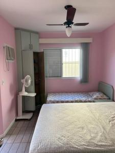 弗洛里亚诺波利斯Apartamento 100 mt da praia em Promoção的一间卧室配有两张床和吊扇
