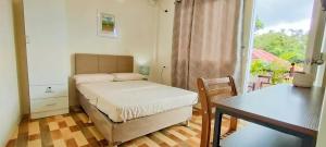邦劳因托伊旅舍的一间小卧室,配有一张床和一张桌子