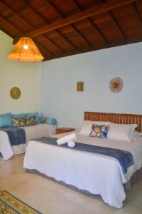 佩德拉斯港Vila Sol Chalés的一间卧室设有两张床和天花板