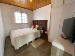 帕普多Hostal La Casona的一间卧室设有一张床、一个窗口和一台电视