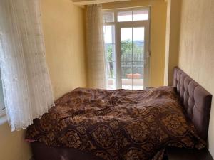 马纳夫加特ormanın içinde geniş havuzlu triplex villa的窗户和床罩的房间里一张床位