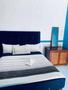 卢萨卡Royal Olympia Lodge Lusaka的一张蓝色和白色的床,上面有白色的碗