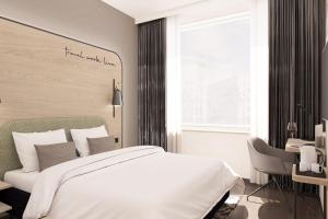 汉诺威June Six Hotel Hannover City的一间卧室配有一张床、一张书桌和一个窗户。