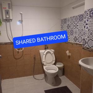 曼谷Happy Hostel的浴室设有卫生间上方的竖有竖立的浴室标志