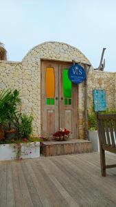 珀尼达岛VnS Beachfront Guesthouse的一座带木门和长凳的建筑