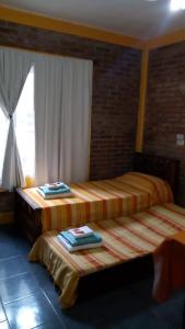 米拉马尔Posada del Flamenco的两张床位于带窗户的房间内