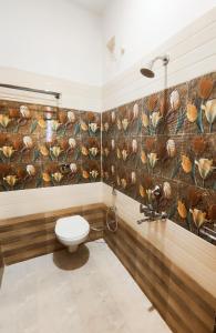 戈勒克布尔HOTEL JVS PALACE的一间带卫生间和花卉壁画的浴室