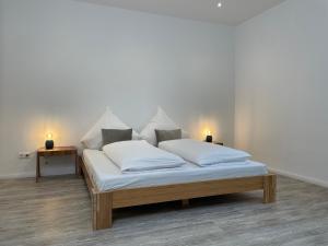 汉诺威SPLENDID I Unique Spacious Apartment的一张带白色床单的床和两张灯