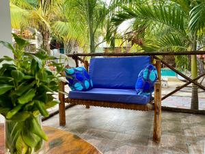 帕杰CeZeRe THE PALM HOTEL的棕榈树庭院的蓝色椅子