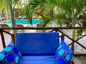 帕杰CeZeRe THE PALM HOTEL的蓝色椅子和蓝色枕头,位于游泳池旁