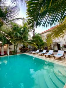 帕杰CeZeRe THE PALM HOTEL的一个带躺椅的游泳池,棕榈树
