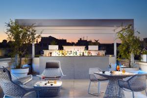 罗马帕拉佐蒙特玛提尼罗马酒店 - 拉迪森连锁酒店的一个带桌椅的屋顶露台和一间酒吧