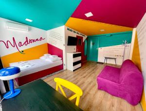 卡托维兹Good Times House的色彩缤纷的客房配有一张床和一把椅子