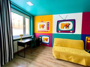 卡托维兹Good Times House的一间卧室拥有色彩缤纷的墙壁、一张床和窗户