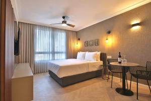 海法Luxury Suites by Notaly Ariel - Carmel Beach的酒店客房带一张床、一张桌子和椅子