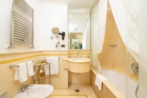 威尼斯亚拉克米狄亚酒店的浴室配有盥洗盆、卫生间和浴缸。