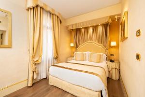 威尼斯亚拉克米狄亚酒店的一间卧室设有一张大床和一个窗户。