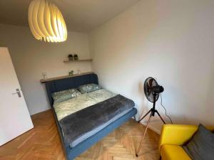 格拉茨Studio Angelina im 3 OG 30 m²的一间卧室配有一张床、一个风扇和一盏灯。