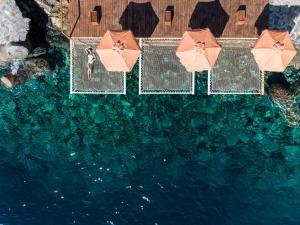 伊罗达Aquila Elounda Village Resort, Suites & Spa的享有带遮阳伞的游泳池的顶部景致