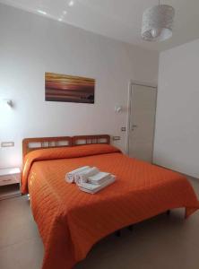 阿杰罗拉CASA VACANZE CASANOVA的一间卧室配有橙色床和2条毛巾