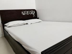 达卡Hotel Labbaik Dhanmondi的一张白色的床,上面有两个枕头