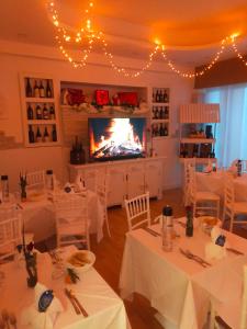 马里纳-迪-皮特拉桑塔MILANO的一间设有白色桌子和壁炉的用餐室