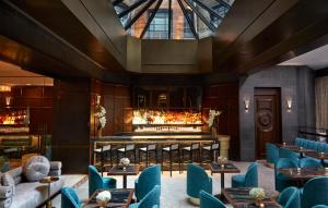 纽约Hotel Belleclaire Central Park的一间设有蓝色椅子的餐厅和一间酒吧