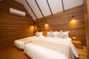 涛岛Ban's Diving Resort SHA Extra Plus的木墙客房的两张床