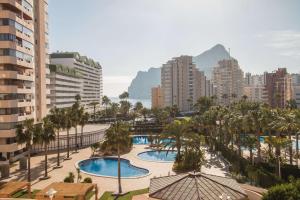 卡尔佩Apartamento Coral Beach - PlusHolidays的一座拥有两个游泳池和棕榈树的城市