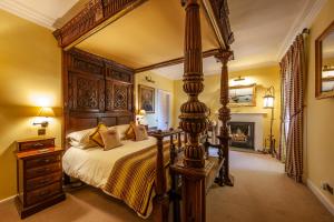 奥本Barcaldine Castle的一间卧室设有一张大天蓬床和一个壁炉
