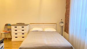 塔尔图Filosoofi 1 Studio Apartments的一间小卧室,配有一张床和一个梳妆台