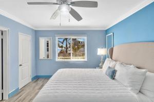 好莱坞Walkabout 8 Tower Suite with Panoramic Ocean Views的蓝色卧室配有床和吊扇