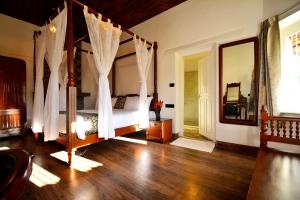 科代卡纳尔Craigmore By Kodai Resort Hotel的一间卧室配有天蓬床和镜子