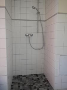 ZempowFerienlandhaus Zempow的浴室铺有白色瓷砖,设有淋浴。