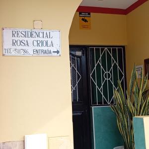 萨尔雷Residencial Rosa Criola的建筑物一侧有标志的黑色门