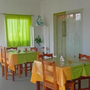 萨尔雷Residencial Rosa Criola的用餐室设有两张黄色和绿色的桌子