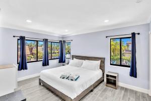 劳德代尔堡Las Olas Luxury 2BR Apt Pool的一间卧室配有一张带蓝色窗帘和窗户的床。
