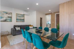 里斯本Apartamento Moderno com Terraço的一间设有玻璃桌和绿色椅子的用餐室