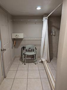 基西米Hotel Monte Carlo的椅子,位于带淋浴的房间